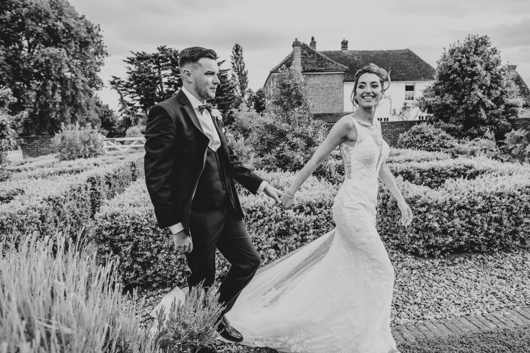 Bride and groom walk in gardens at Villiers Barn