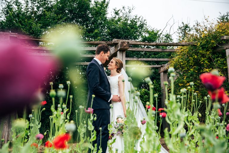 Bride and groom stand in back garden for diy wedding