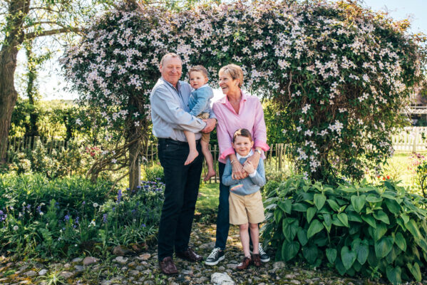 grandparents cuddle grandsons in back garden Essex family lifestyle baby childhood photographer