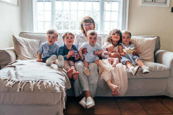 Nanna cuddles on sofa at home with her six grandchildren Essex lifestyle family childhood baby photographer