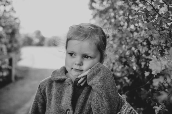 Little girl looks serious on a bridge in park Essex lifestyle family childhood baby photographer