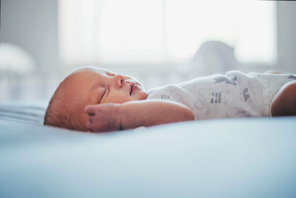 Baby girl sleeps on bed at home Essex lifestyle family baby childhood photographer