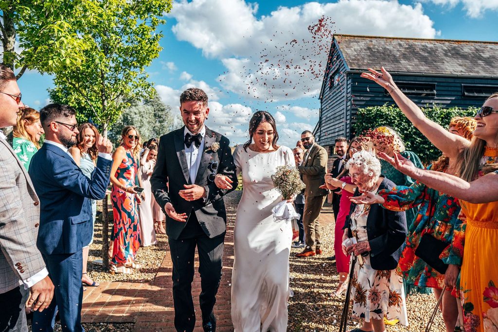 Impossibly chic, black tie wedding at The Hare's Field, with Bridesmaids in mismatched pinks and dried flowers. Best Essex Documentary Wedding Photographer
