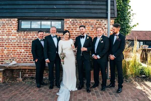 Impossibly chic, black tie wedding at The Hare's Field, with Bridesmaids in mismatched pinks and dried flowers. Best Essex Documentary Wedding Photographer