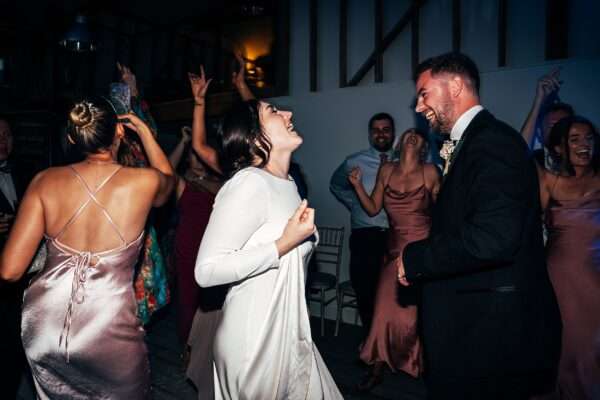 Impossibly chic, black tie wedding at The Hare's Field, with Bridesmaids in mismatched pinks and dried flowers. Best Essex Documentary Wedding Photographer