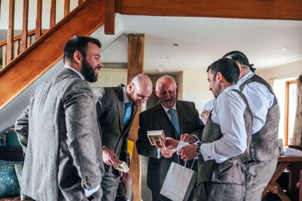 Groomsmen open gifts before wedding at Captains Wood Barn