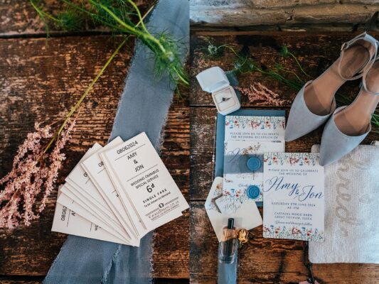 Bridal detail, including cornflower blue shoes, perfume, jewellery, beaded handbag, invitations for Captains Wood Barn Wedding