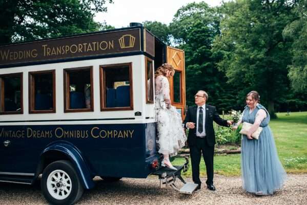 Bride arrives at for Captains Wood Barn wedding in vintage bus