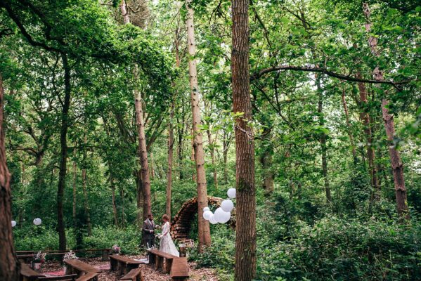 Bride and Groom toast each other in woodland ceremony space at Captains Wood Barn