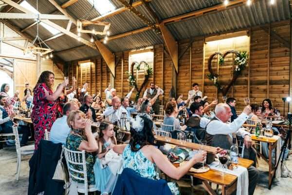 Guests laugh at speeches at Captains Wood Barn Essex documentary wedding photographer