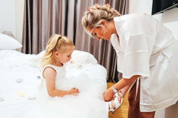 Bride puts on daughter's shoes during bridal prep