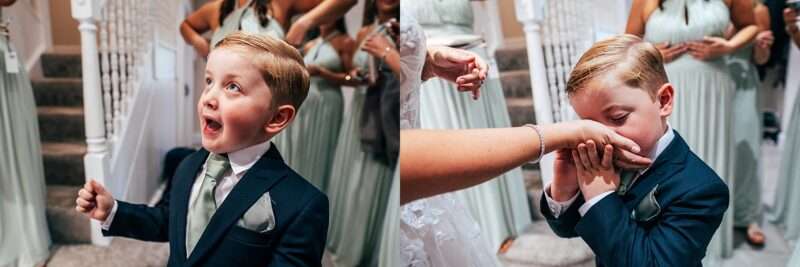 Brides son in suit kisses her hand during bridal prep