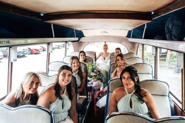 Bride and bridesmaids in vintage bus arrive at church