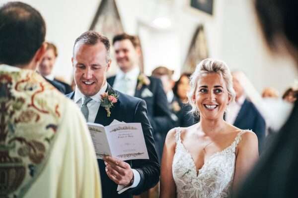 smiling bride and groom during wedding in church