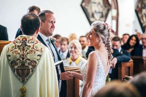 bride and groom exchange vows in church ceremony