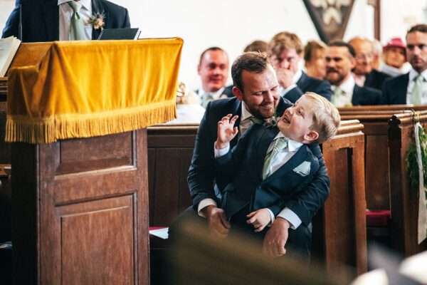 Best Man make Page Boy laugh during church ceremony