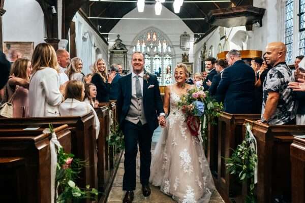 Bride and Groom walk up aisle after church ceremony