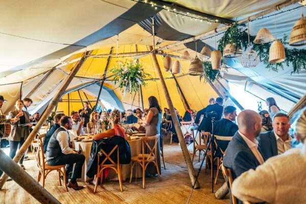 guests seated in tipi in Essex back garden wedding