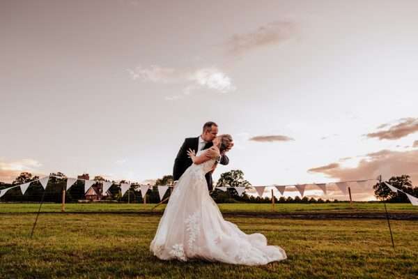 bride and groom kiss at sunset for their Essex back garden tipi wedding