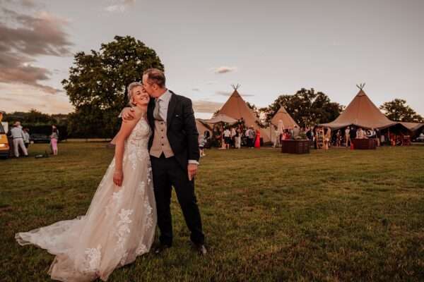 Bride and Groom kiss at sunset for their Essex back garden tipi wedding