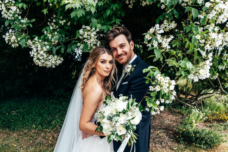 Bride and Groom under blossom tree at Blake Hall Best Essex wedding photographer