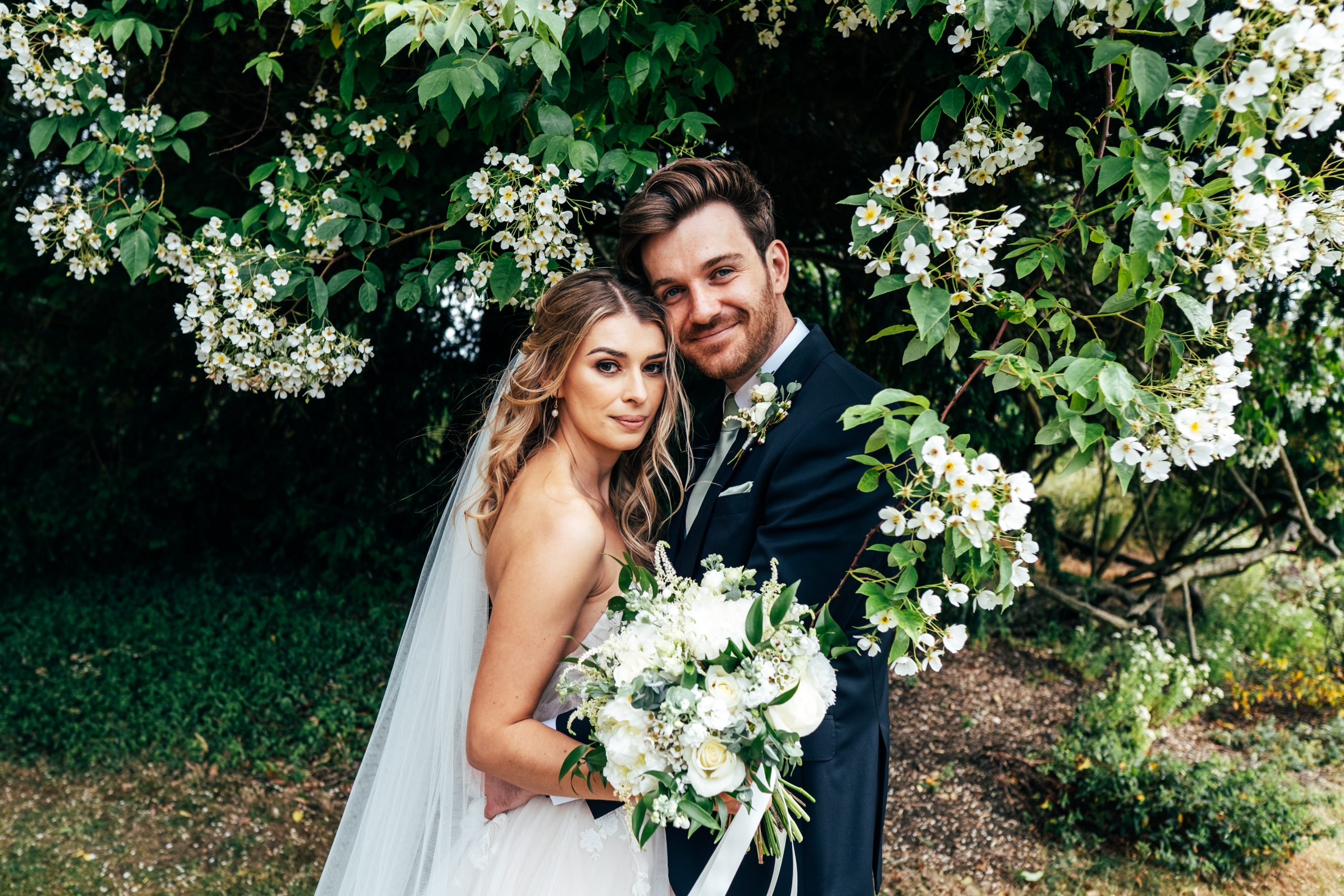 Bride and Groom under blossom tree at Blake Hall Best Essex wedding photographer