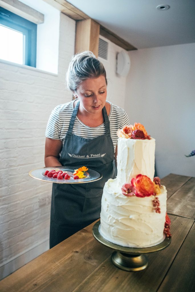 Essex Branding, Content and Head Shot photographer Woman in apron decorates cake for Gather & Feast Events
