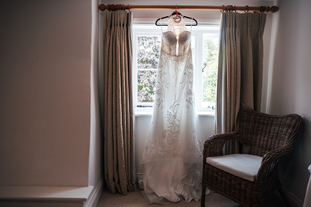 wedding dress hanging from window at Blake Hall