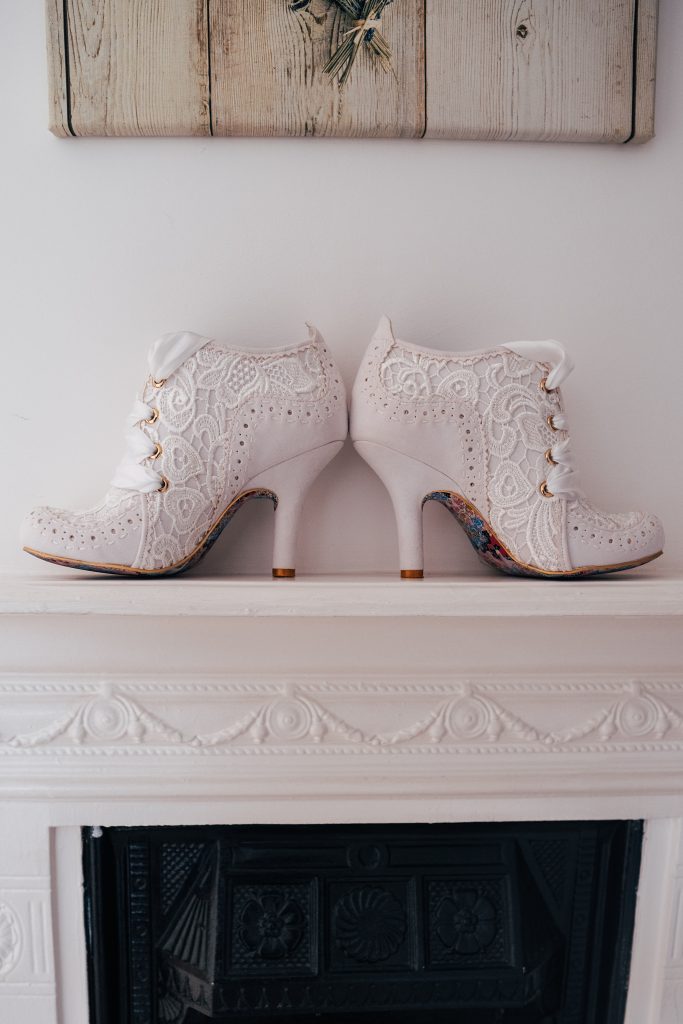 white lace detailed heeled boots on a fireplace