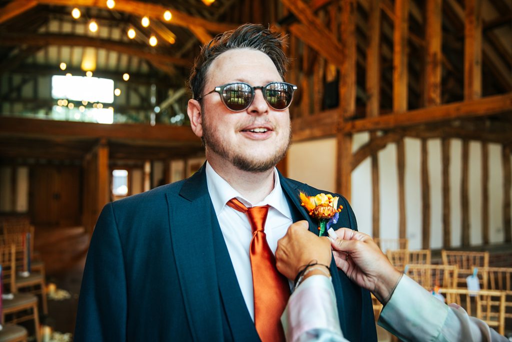 Groom has orange button hole put on