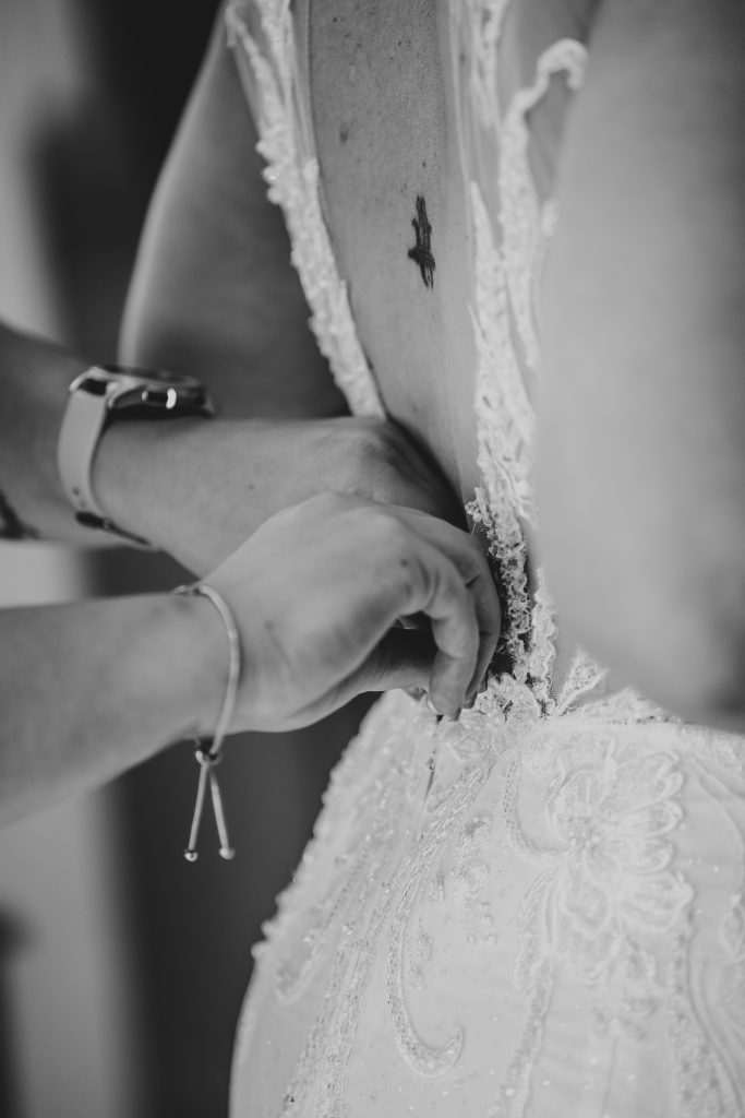 close up of brides dress being fastened