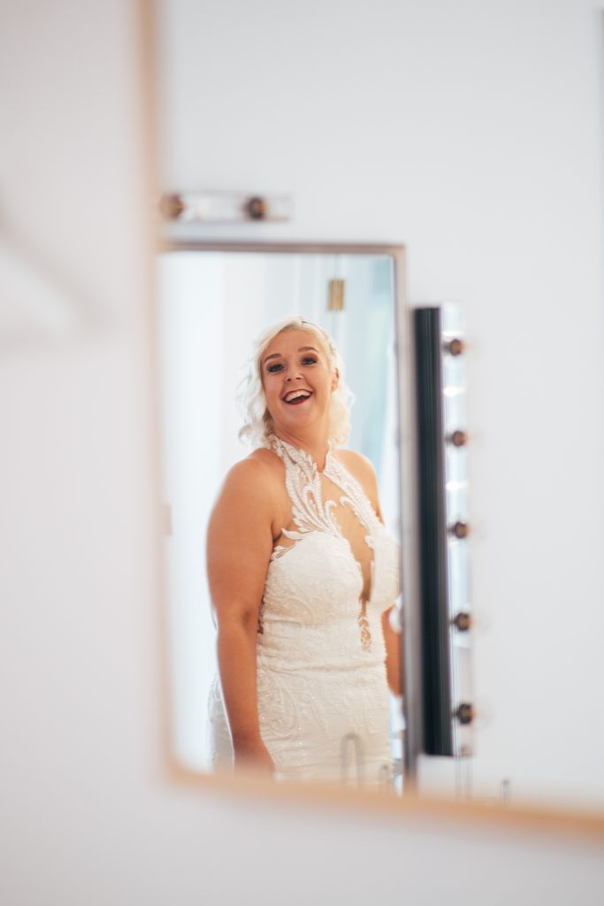 double reflection of laughing bride in prep room