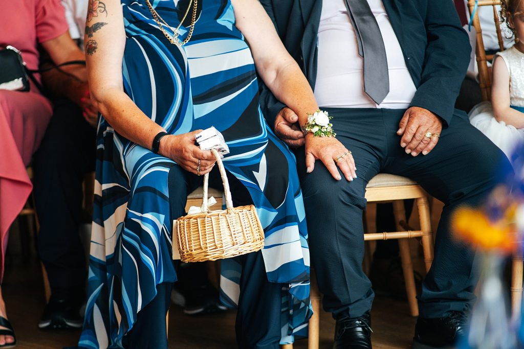 parents of groom hold hands during ceremony