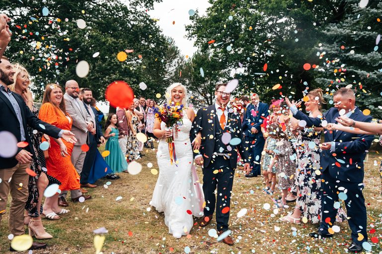 bride and groom have big, bold confetti thrown on them