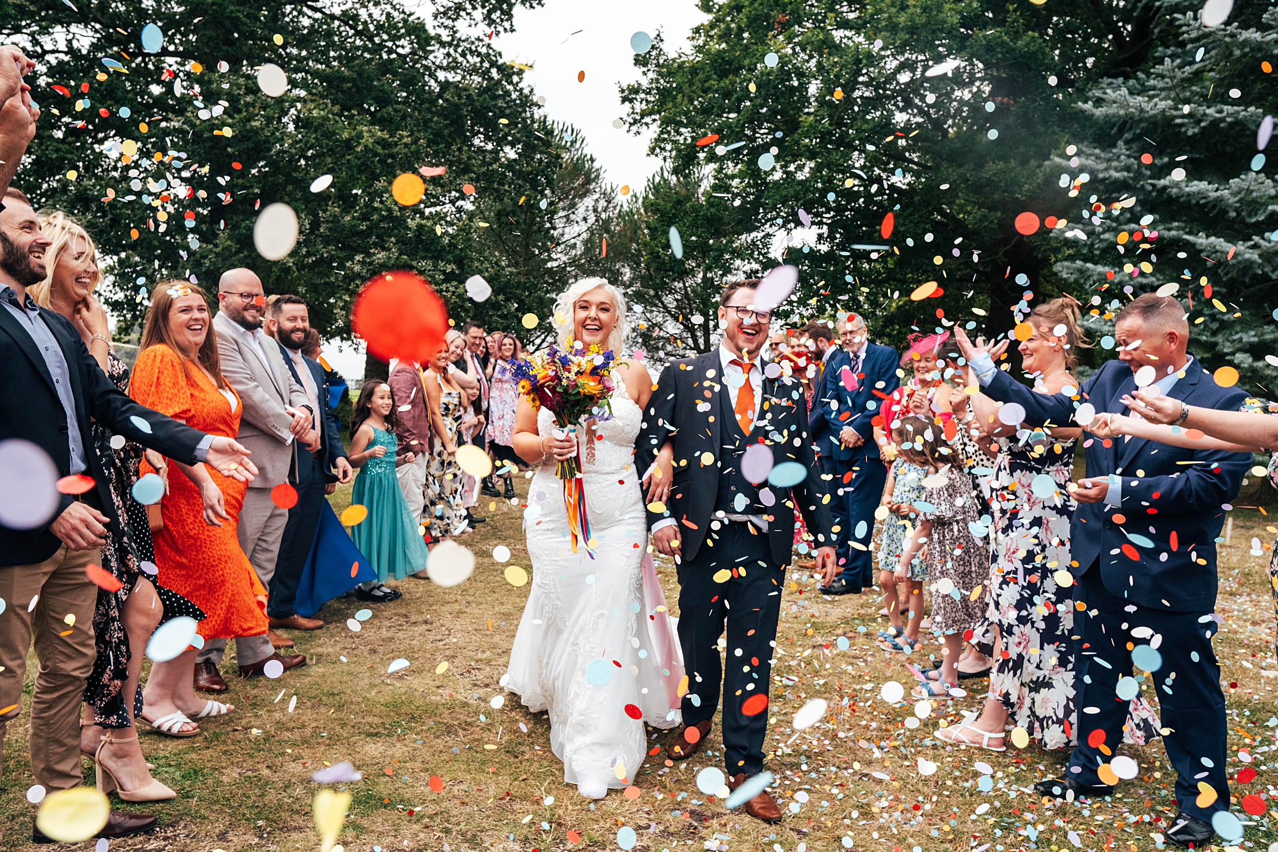 bride and groom have big, bold confetti thrown on them