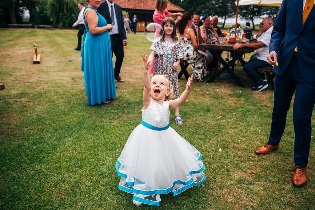 flower girl blows bubbles