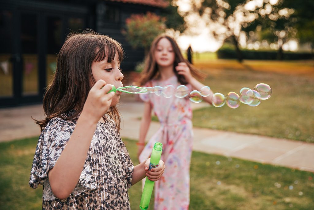 little girl blows bubbles
