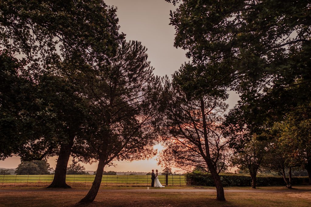 wide shot of bride and groom during sunset