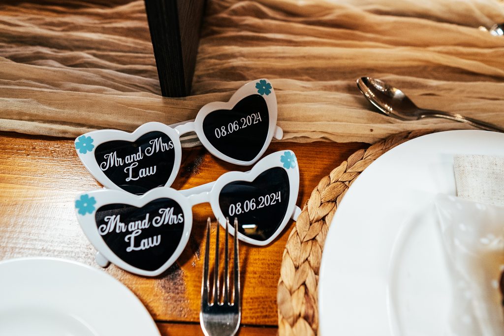 dated and named heart shaped sunglasses on a table