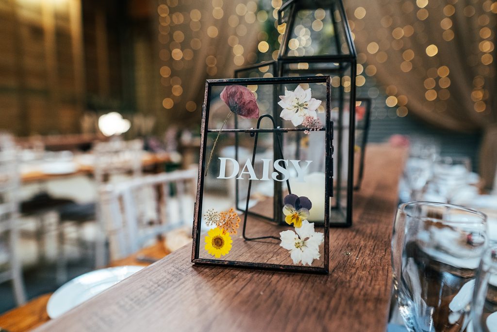 metal frame with pressed flowers inside on trestle table