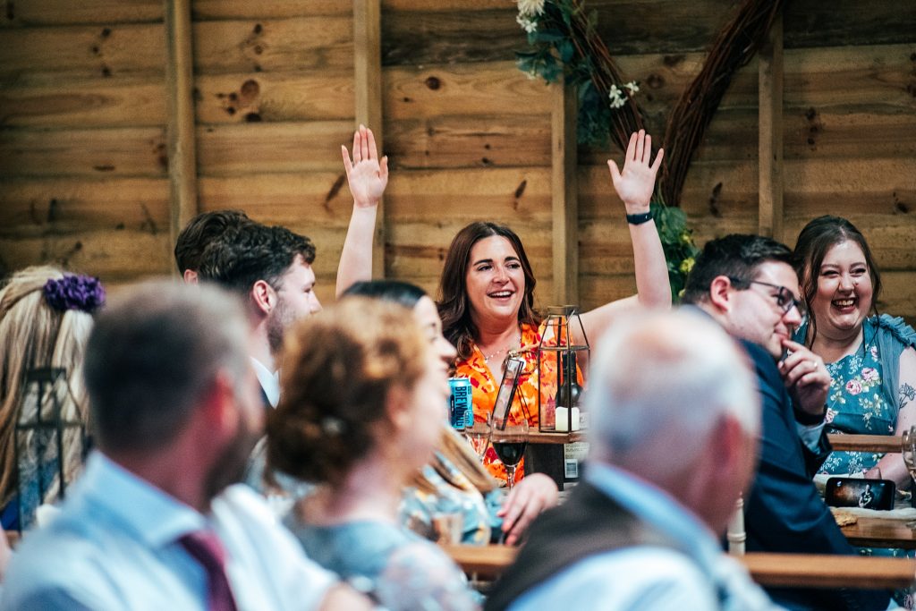 wedding guest holds hands in air during speeches