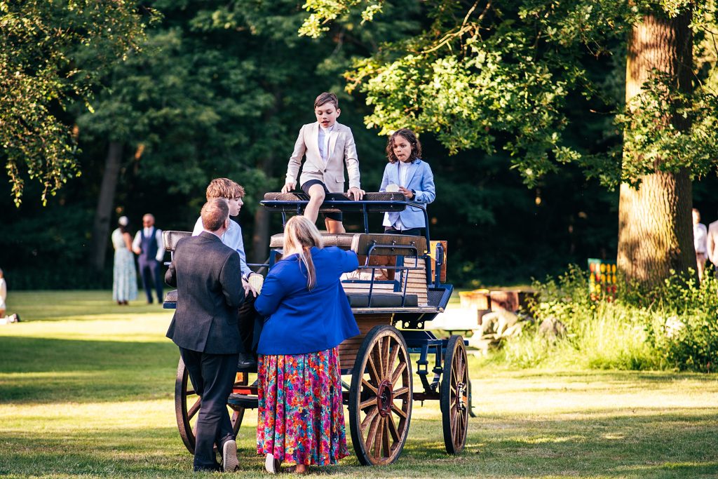 kids climb on horse cart at a wedding