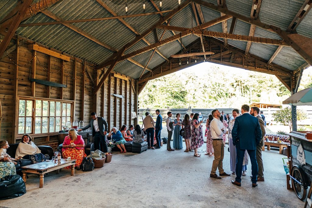 wedding guests mingle in a barn