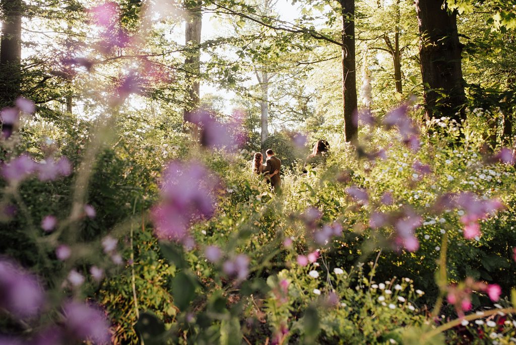 bride and groom in meadow at sunset framed by purple flowers