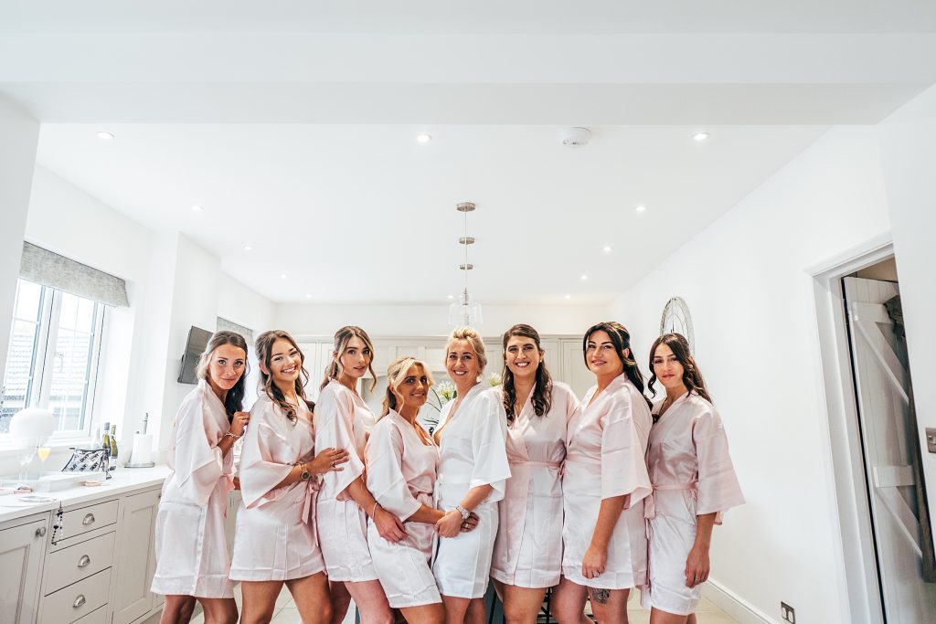 bride with bridesmaids in dressing gown in kitchen before wedding