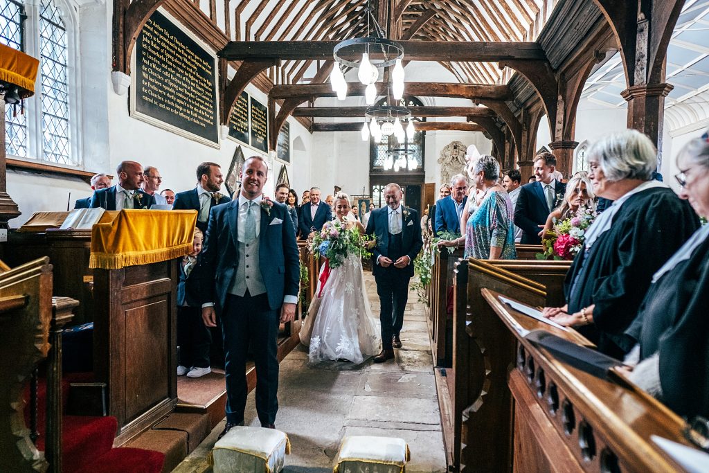 bride walks down aisle with dad in church