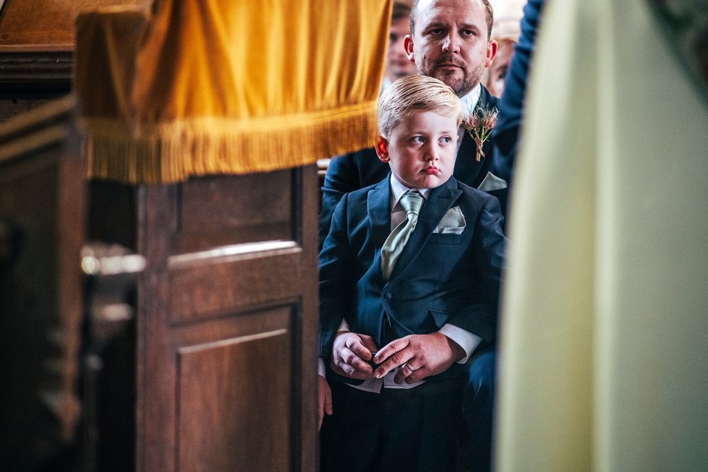 page boy looks bored in church