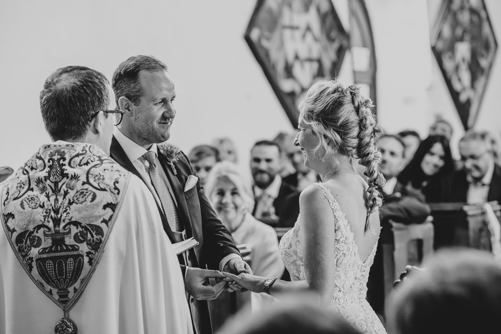 bride and groom exchange rings in church