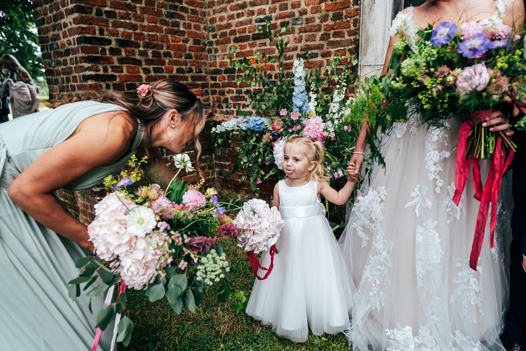 flower girl sticks out tongue to bridesmaid