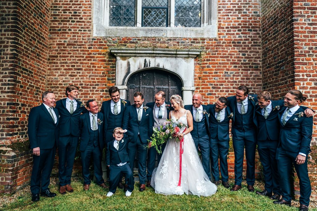bride groom and groomsmen outside church